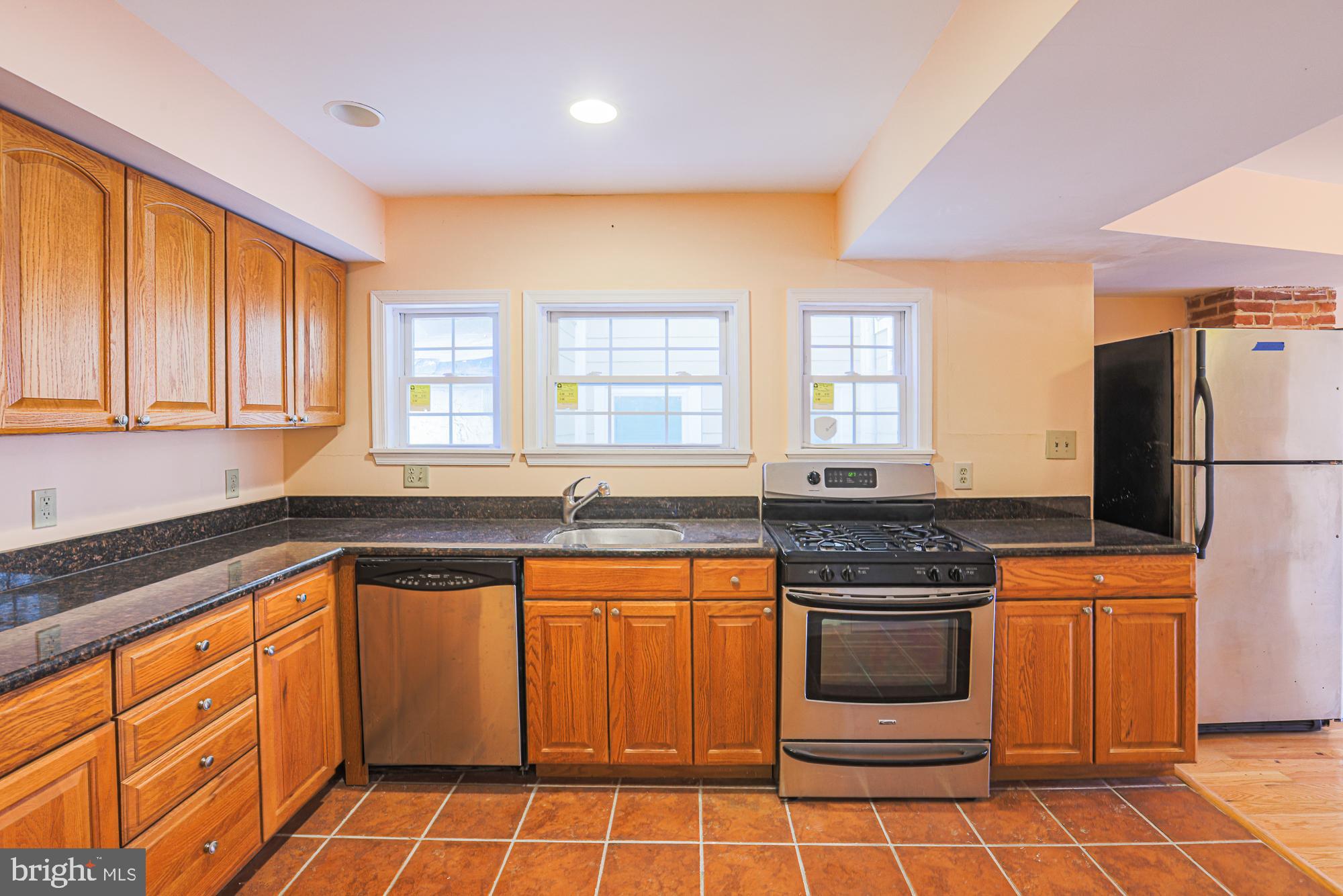 1447 William Street Baltimore, MD 21230 - Photo 45 of 72 a kitchen with stainless steel appliances granite countertop a stove a sink and a refrigerator
