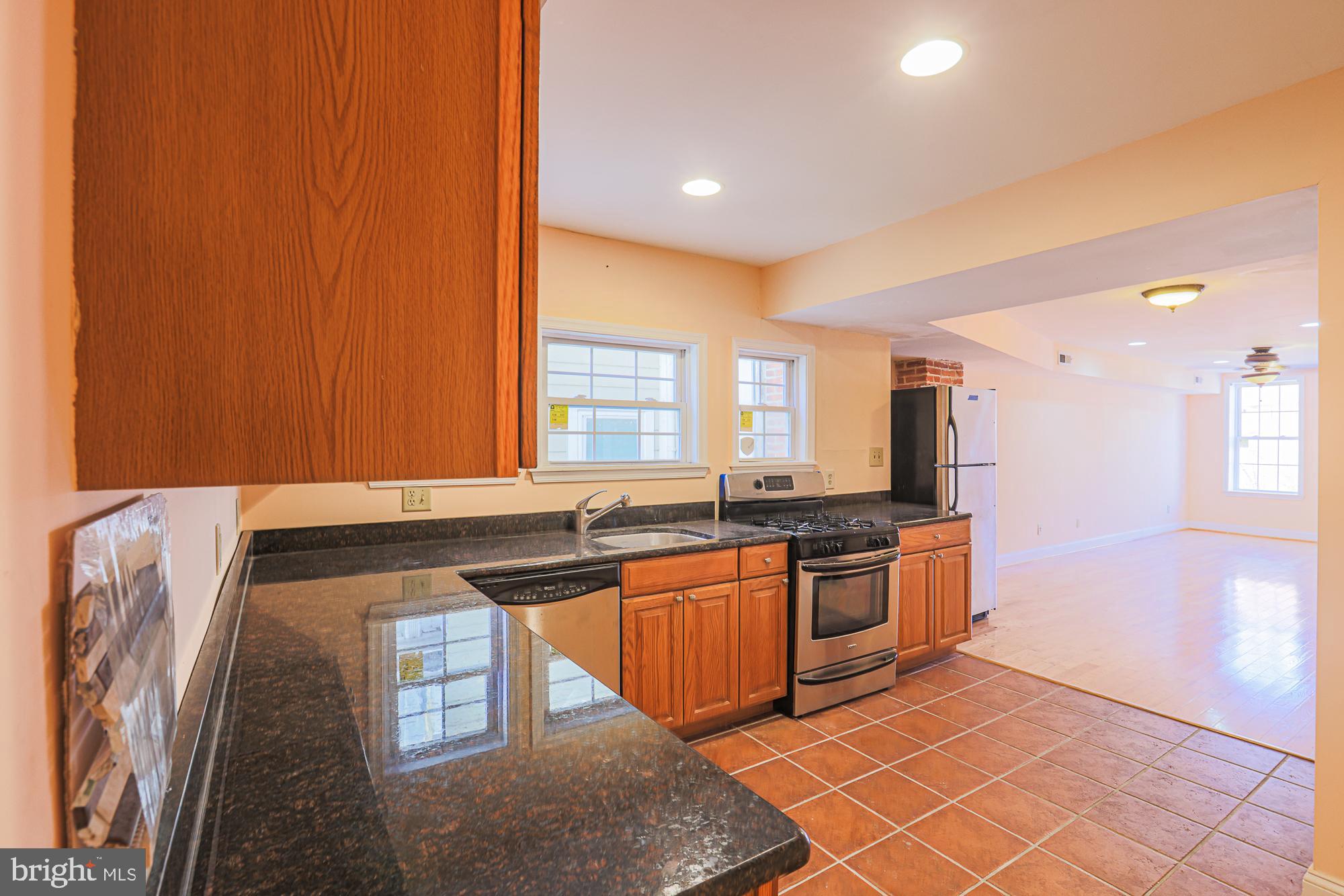 1447 William Street Baltimore, MD 21230 - Photo 46 of 72 a kitchen with stainless steel appliances granite countertop a sink and a stove