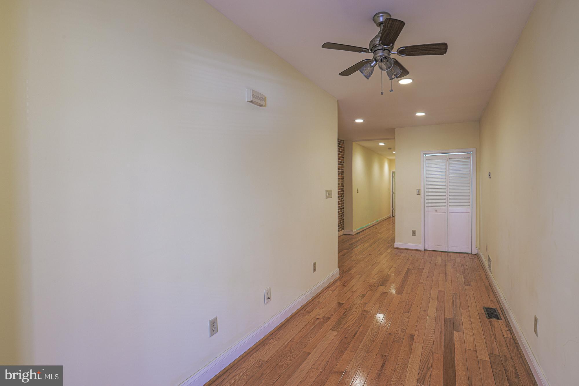 1447 William Street Baltimore, MD 21230 - Photo 7 of 72 a view of a big room with wooden floor and a ceiling fan