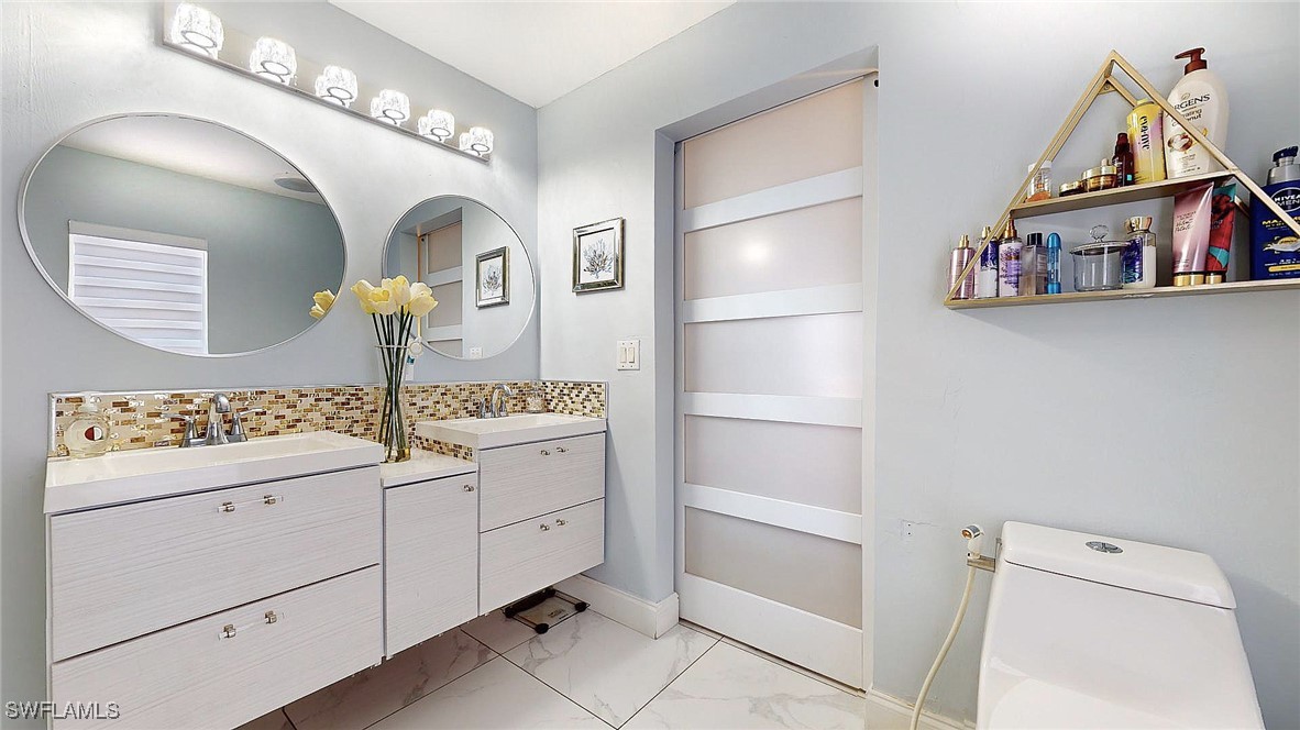 2602 5th Street Southwest Lehigh Acres, FL 33976 - Photo 11 of 17 a bathroom with a sink a vanity and a mirror