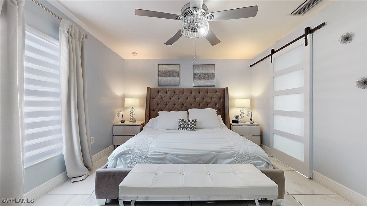 2602 5th Street Southwest Lehigh Acres, FL 33976 - Photo 10 of 17 a bedroom with a bed and a chandelier