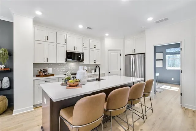 a kitchen with a dining table chairs and refrigerator