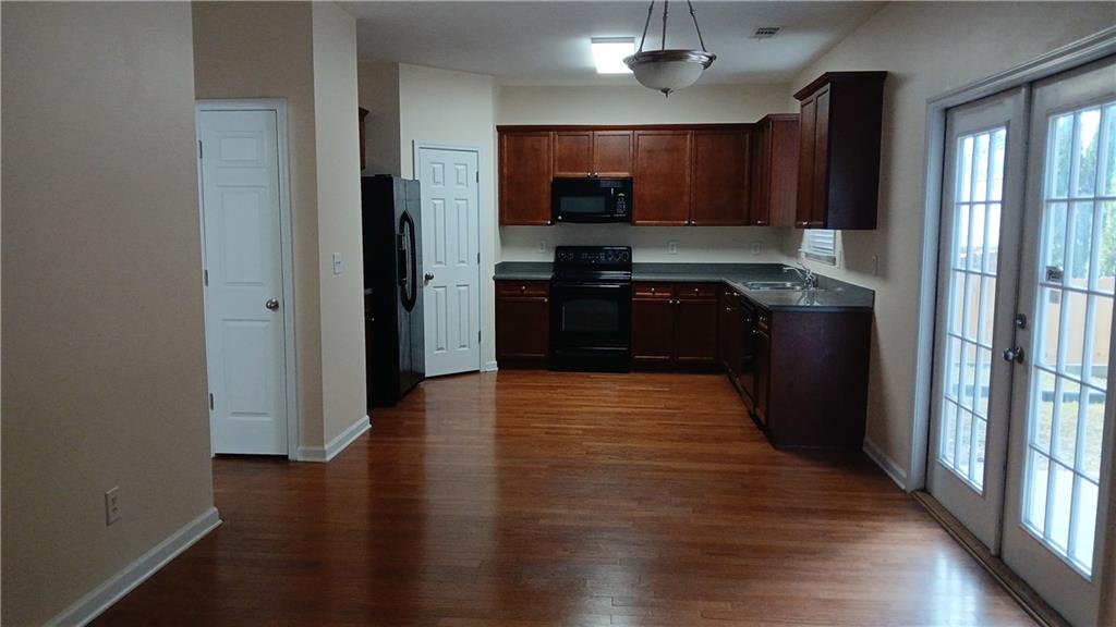 5966 Haddon Place Southeast Mableton, GA 30126 - Photo 9 of 35 a kitchen with stainless steel appliances granite countertop wooden cabinets a refrigerator a stove a sink and dishwasher with wooden floor