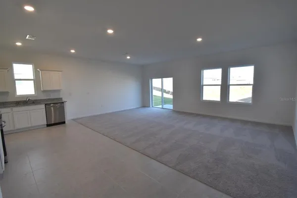 an empty room with windows and fireplace