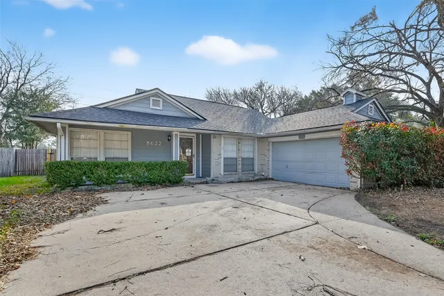 a front view of a house with a yard and a garage