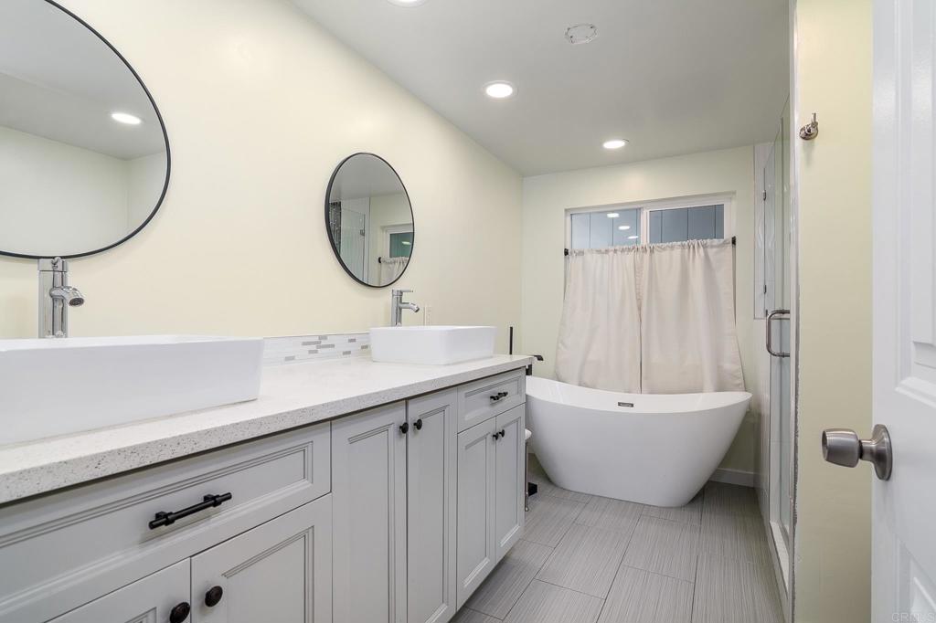 500 Rancheros Drive, Unit 73 San Marcos, CA 92069 - Photo 18 of 52 a bathroom with a double vanity sink mirror and bathtub