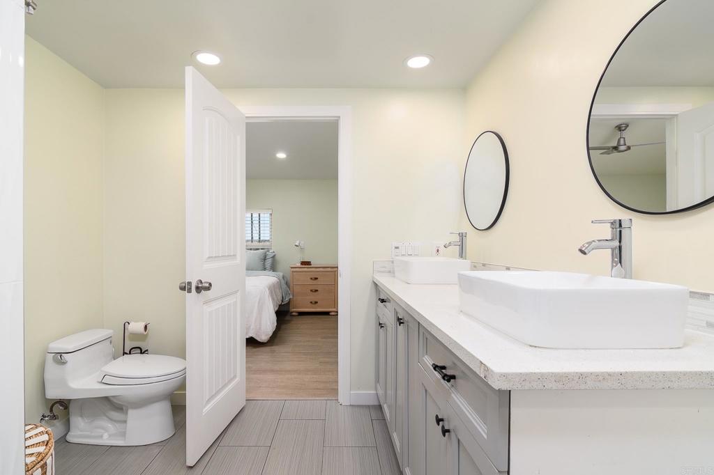 500 Rancheros Drive, Unit 73 San Marcos, CA 92069 - Photo 19 of 52 a spacious bathroom with a toilet a sink and a mirror