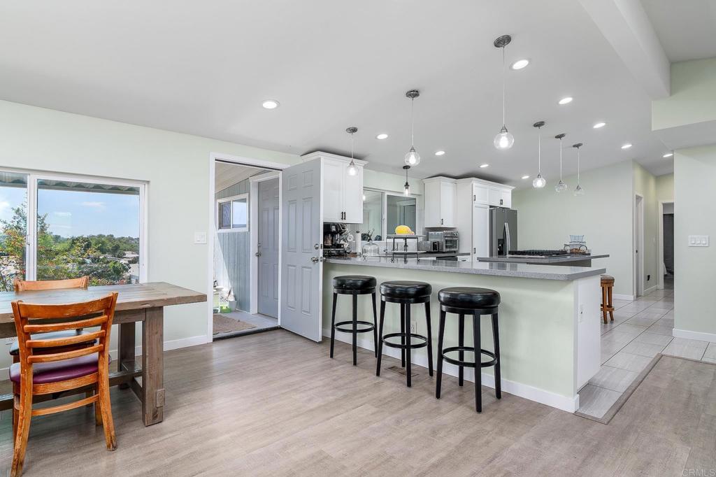 500 Rancheros Drive, Unit 73 San Marcos, CA 92069 - Photo 5 of 52 a kitchen with a dining table chairs wooden floor appliances and cabinets