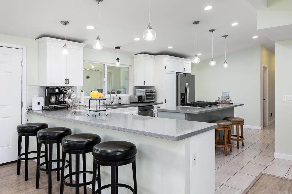 500 Rancheros Drive, Unit 73 San Marcos, CA 92069 - Photo 10 of 52 a kitchen with stainless steel appliances kitchen island granite countertop a table and chairs