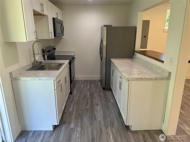 a kitchen with a sink a refrigerator and a stove top oven
