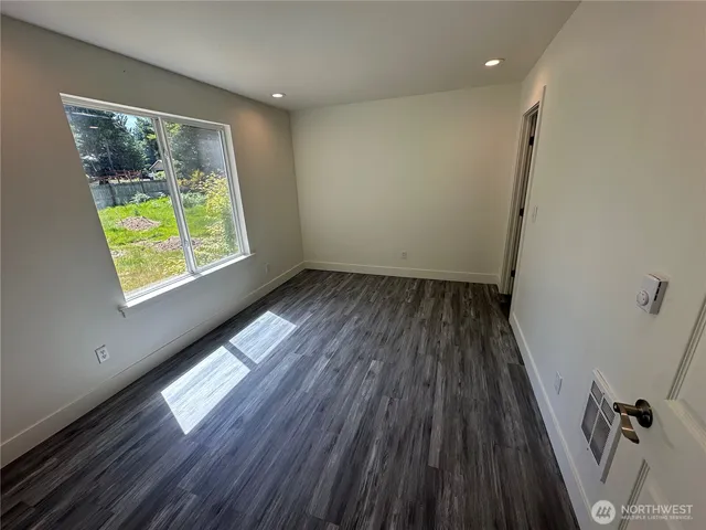 a view of hallway with a window and wooden floor
