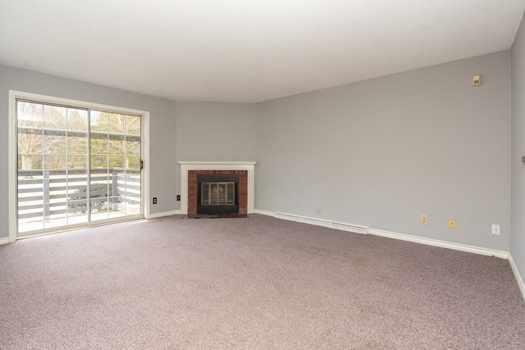 104 Johnson Road, Unit 106 Chicopee, MA 01022 - Photo 4 of 24 an empty room with furniture and a fireplace