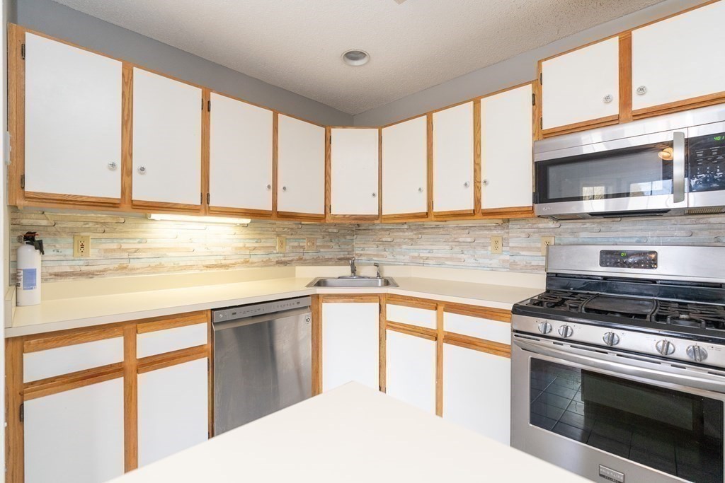 104 Johnson Road, Unit 106 Chicopee, MA 01022 - Photo 8 of 24 a kitchen with stainless steel appliances a stove sink and cabinets