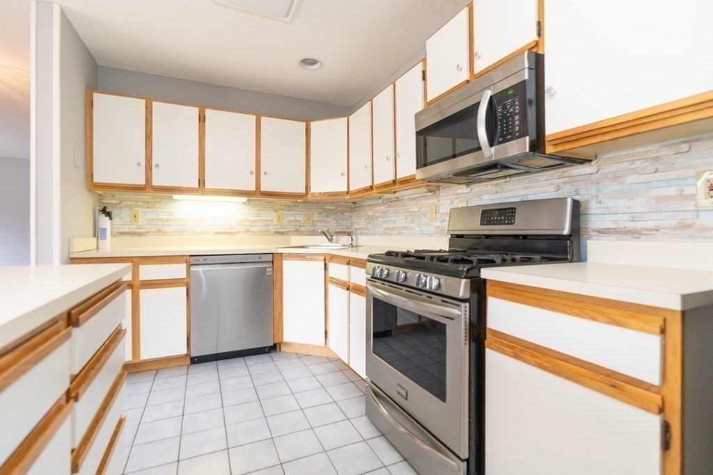 104 Johnson Road, Unit 106 Chicopee, MA 01022 - Photo 9 of 24 a kitchen with stainless steel appliances granite countertop a sink and a stove