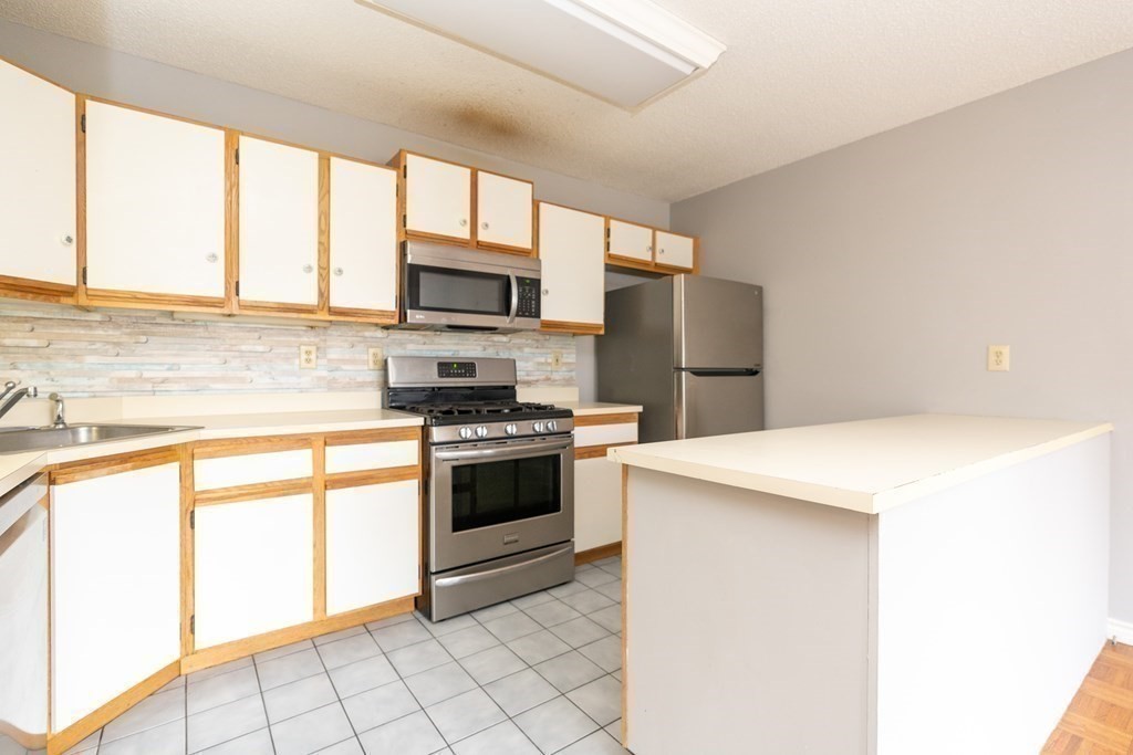 104 Johnson Road, Unit 106 Chicopee, MA 01022 - Photo 10 of 24 a kitchen with stainless steel appliances a stove sink and microwave