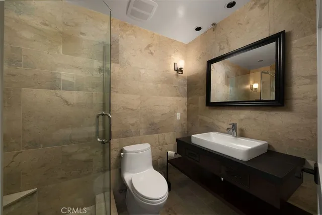 a view of a hallway with wooden floor and a bathroom