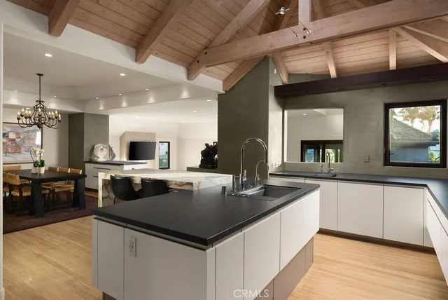 a large kitchen with kitchen island a large counter tops a stove a sink and living room view