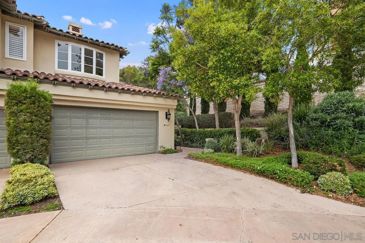 9605 Claiborne Square La Jolla, CA 92037 - Photo 1 of 34 a front view of a house with a garden and trees