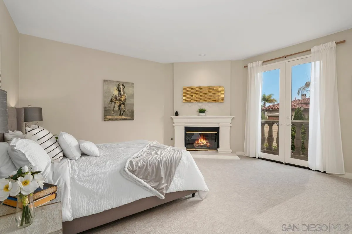 9605 Claiborne Square La Jolla, CA 92037 - Photo 21 of 34 a spacious bedroom with a bed and a fireplace