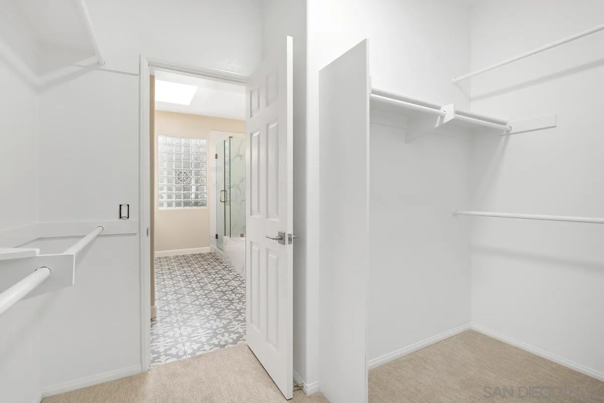 9605 Claiborne Square La Jolla, CA 92037 - Photo 25 of 34 a bathroom with a glass shower door