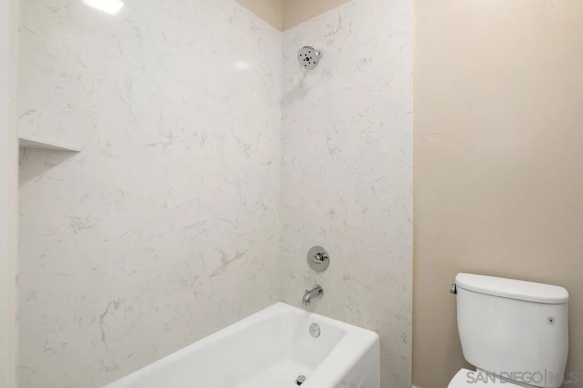 9605 Claiborne Square La Jolla, CA 92037 - Photo 29 of 34 a bath room with a toilet a sink and a shower