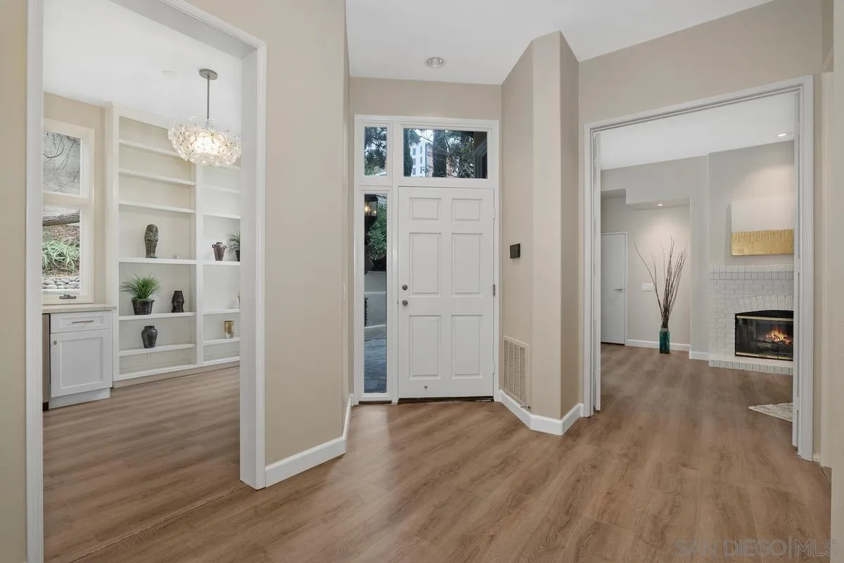 9605 Claiborne Square La Jolla, CA 92037 - Photo 7 of 34 a view of a hallway with wooden floor and a living room