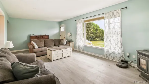 an empty room with wooden floor ceiling fan and windows