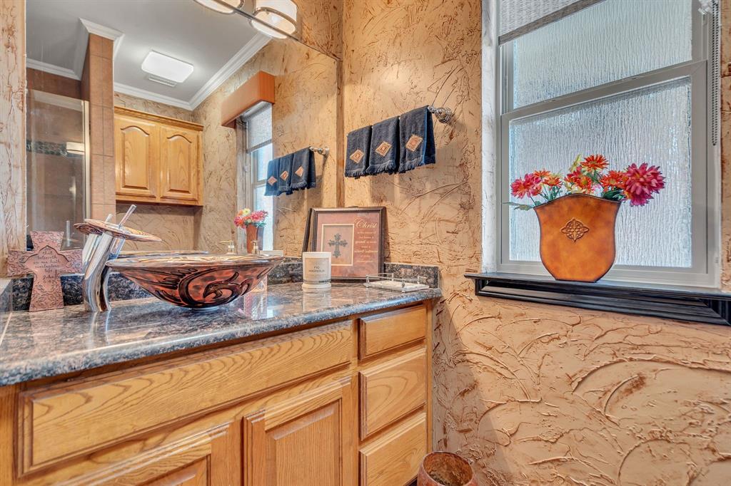 50 Buckingham Lane Allen, TX 75002 - Photo 32 of 39 a bathroom with mirror sink and wooden cabinets
