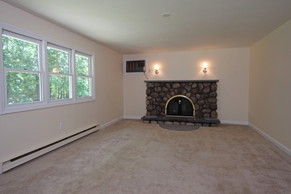 62 Adams Road Townsend, MA 01469 - Photo 4 of 16 an empty room with fireplace and windows