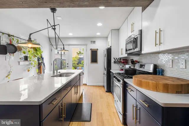 a large kitchen with stainless steel appliances granite countertop a sink a stove and a refrigerator