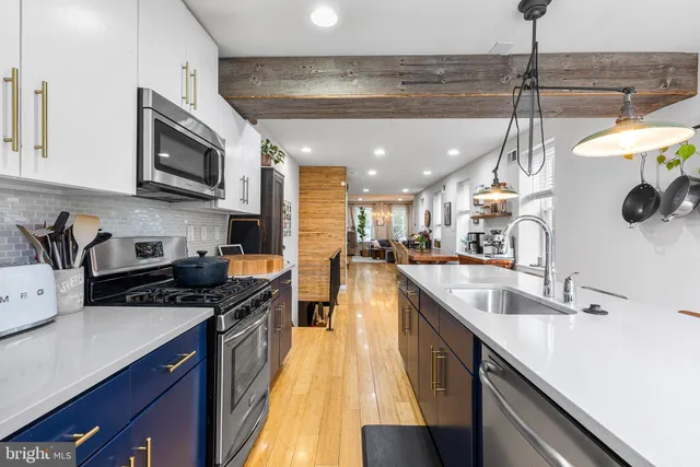 a kitchen with stainless steel appliances granite countertop a sink a stove and a wooden floors