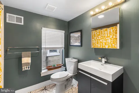 a bathroom with a sink toilet and mirror