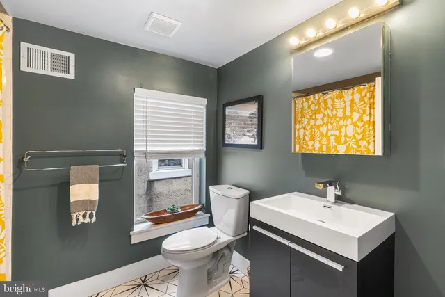 a bathroom with a sink toilet and mirror