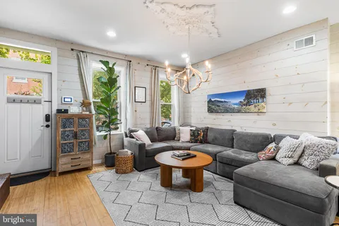 a living room with furniture a chandelier and a flat screen tv