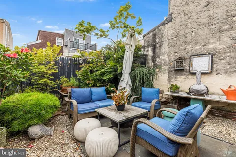 a view of a patio with couches table and chairs and potted plants