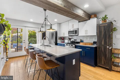 a kitchen with kitchen island granite countertop a sink stove and refrigerator