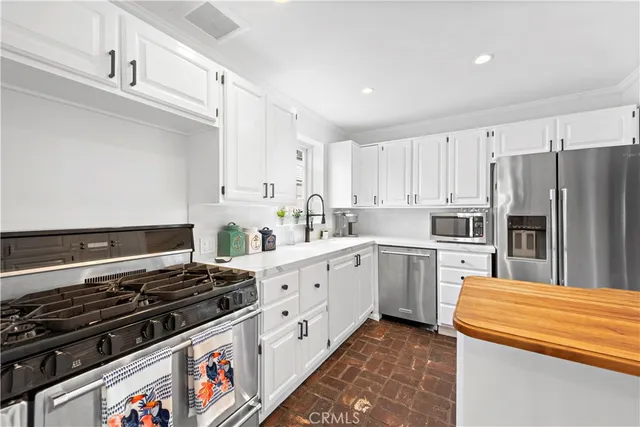 a kitchen with white cabinets and appliances