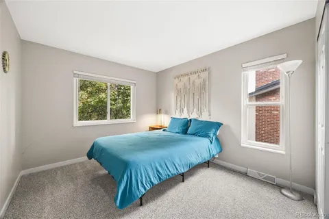 a bedroom with a bed and windows