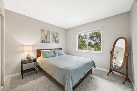 a bedroom with a bed and a painting on the wall