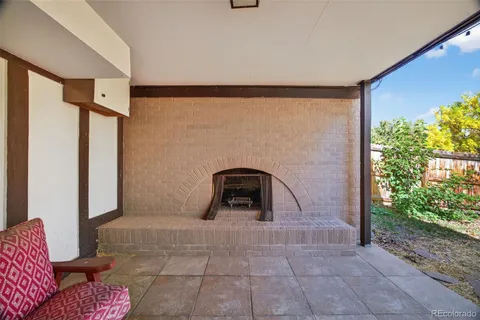 a backyard of a house with plants and large tree