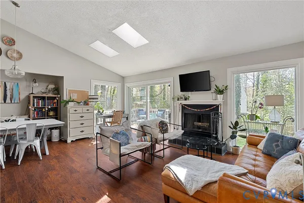 a living room with furniture a flat screen tv and a fireplace