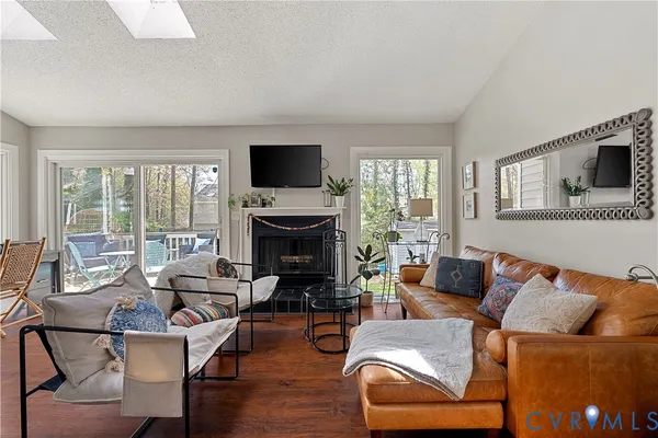 a living room with furniture a fireplace and a flat screen tv