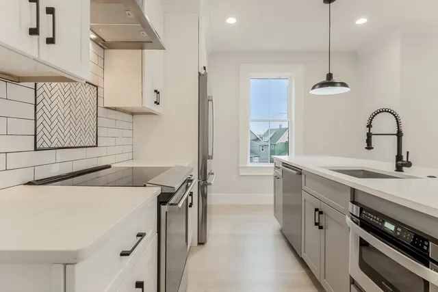 a kitchen with a sink a stove and cabinets