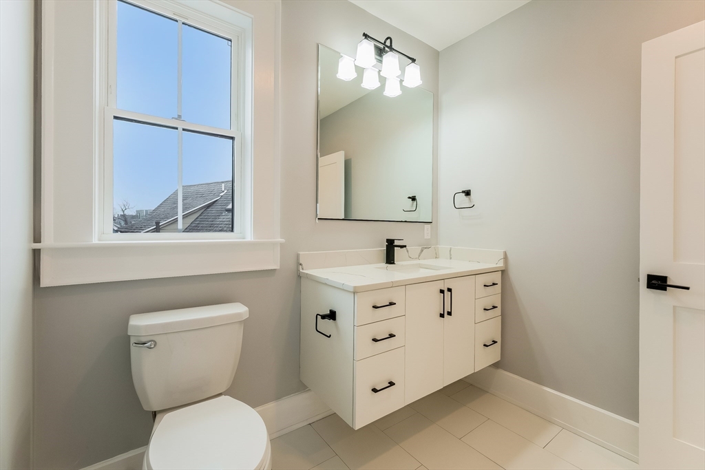 15 McKone Street, Unit 2 Boston, MA 02122 - Photo 22 of 24 a bathroom with a toilet sink and mirror