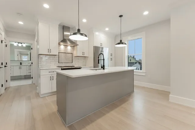 a large kitchen with white cabinets and stainless steel appliances