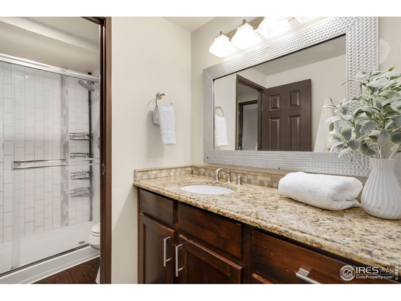 415 South Howes Street, Unit 910 Fort Collins, CO 80521 - Photo 17 of 28 a bathroom with a granite countertop sink and a mirror