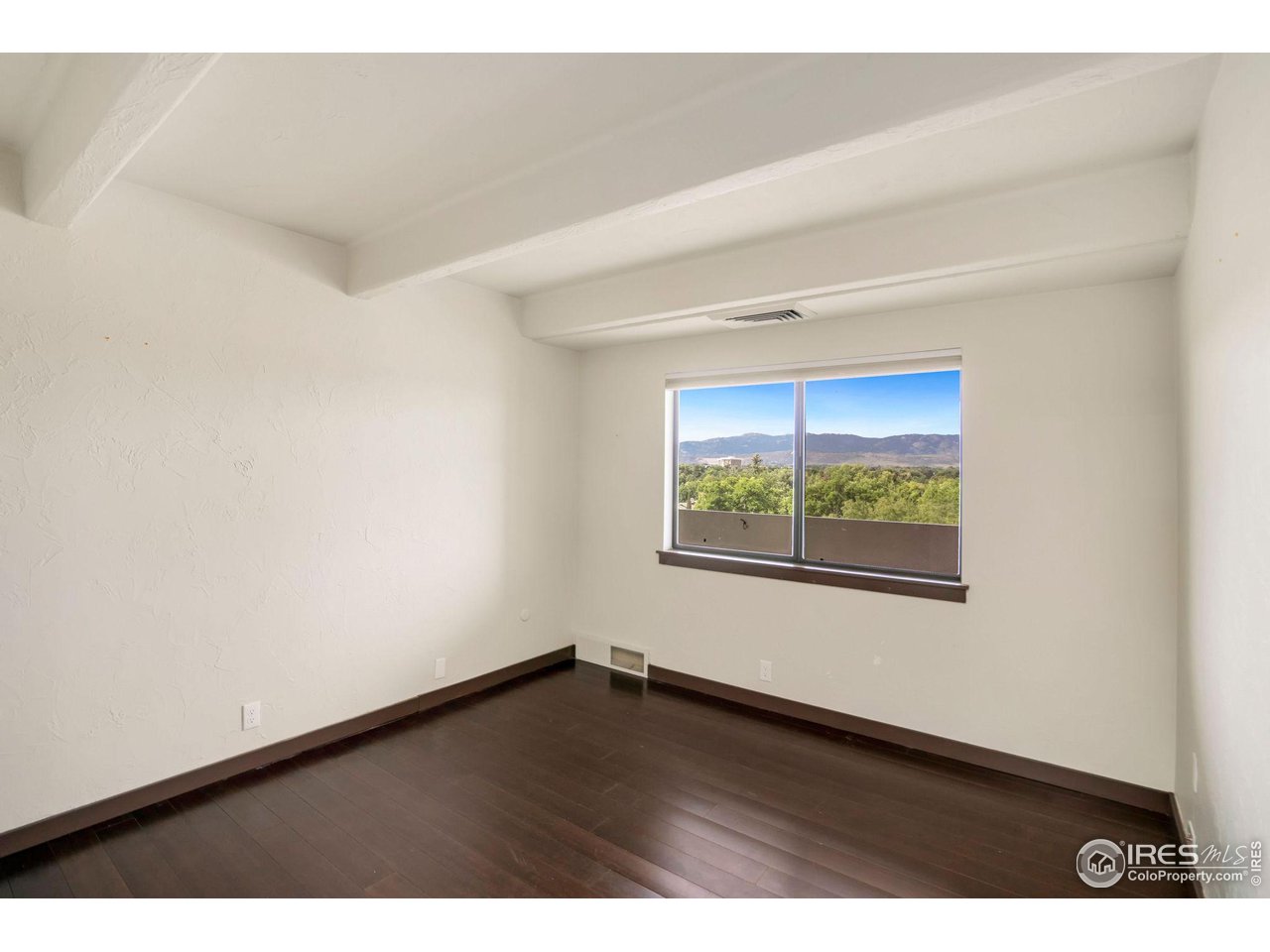 415 South Howes Street, Unit 910 Fort Collins, CO 80521 - Photo 18 of 28 a view of an empty room with wooden floor and a window