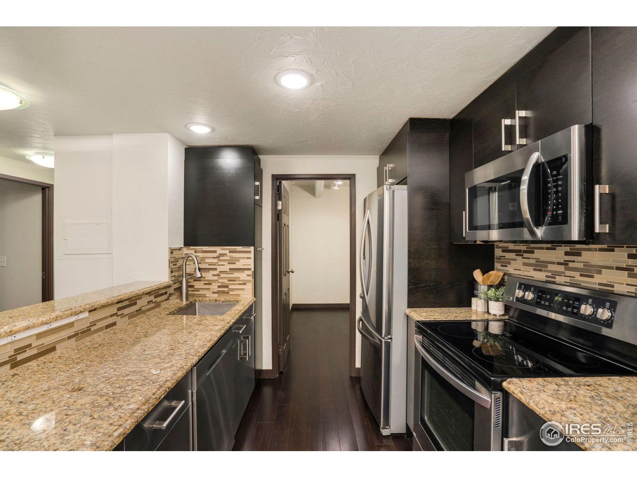 415 South Howes Street, Unit 910 Fort Collins, CO 80521 - Photo 10 of 28 a kitchen with stainless steel appliances granite countertop a sink stove and refrigerator