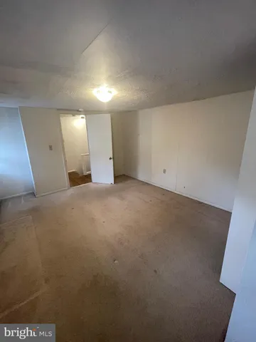 an empty room with a fireplace and windows