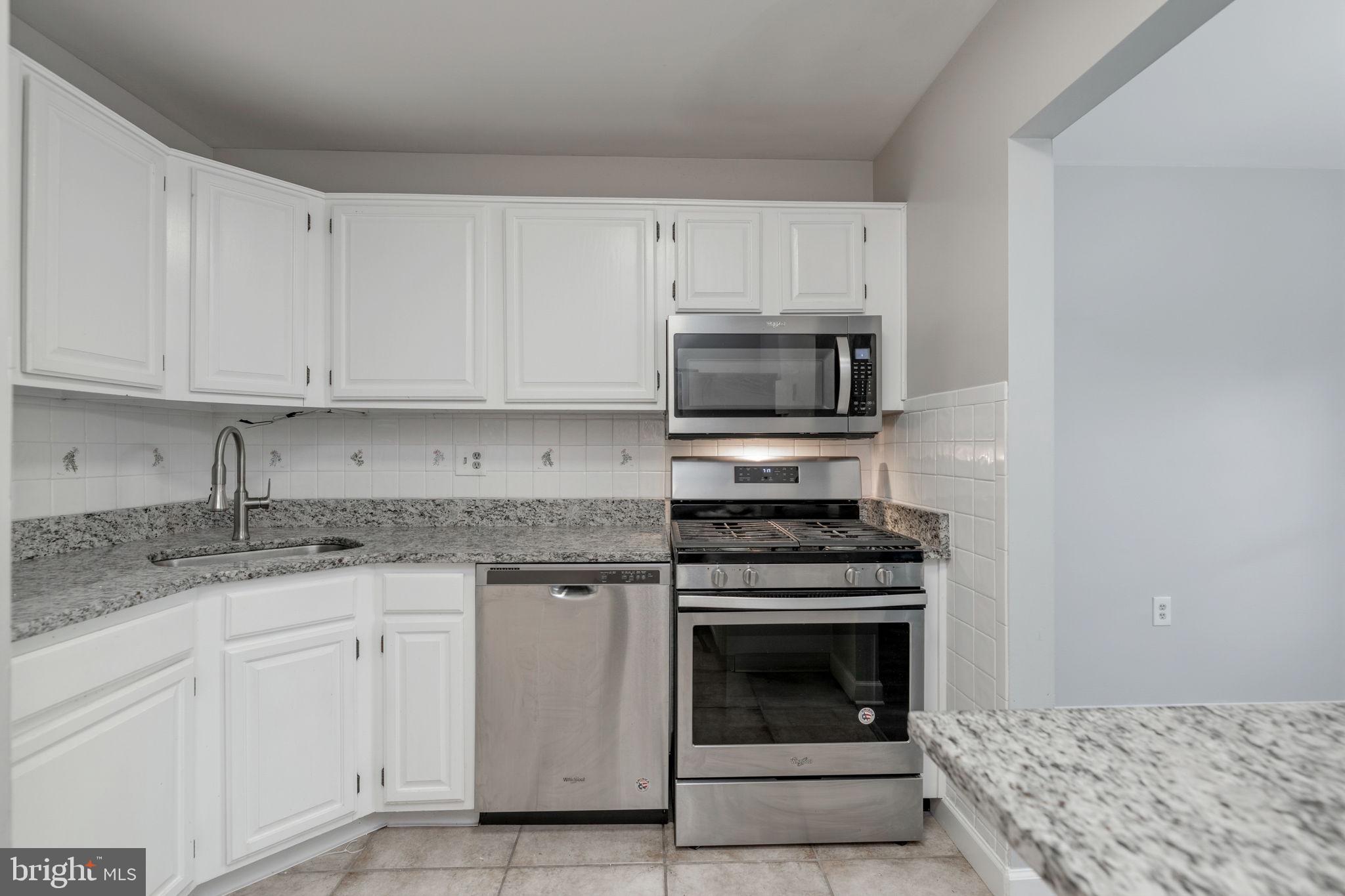 1443 Northgate Square, Unit 22B Reston, VA 20190 - Photo 8 of 42 a kitchen with granite countertop a stove sink and cabinets